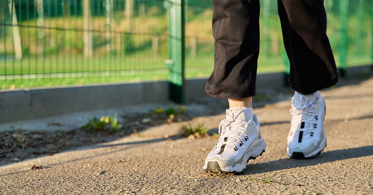 Person taking active steps during an outdoor walk, representing Synergy Health services focused on movement, wellness, and healthy living.