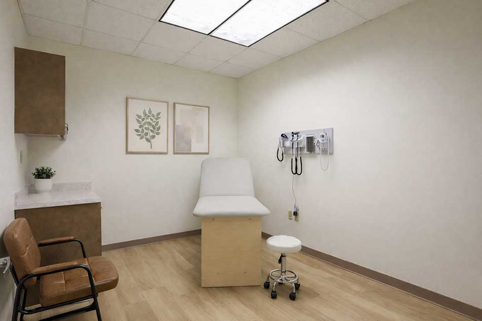 Synergy Health exam room with exam table, stool, and diagnostic wall instruments.