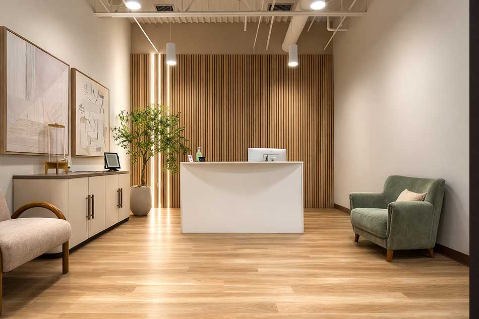 Synergy Health reception area with front desk, wood accent wall, and patient seating.